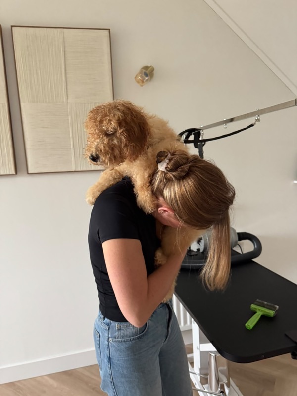 Rianne knuffelt met jonge puppy op haar schouder
